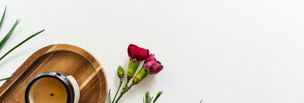 Vela y flores sobre una mesa clara